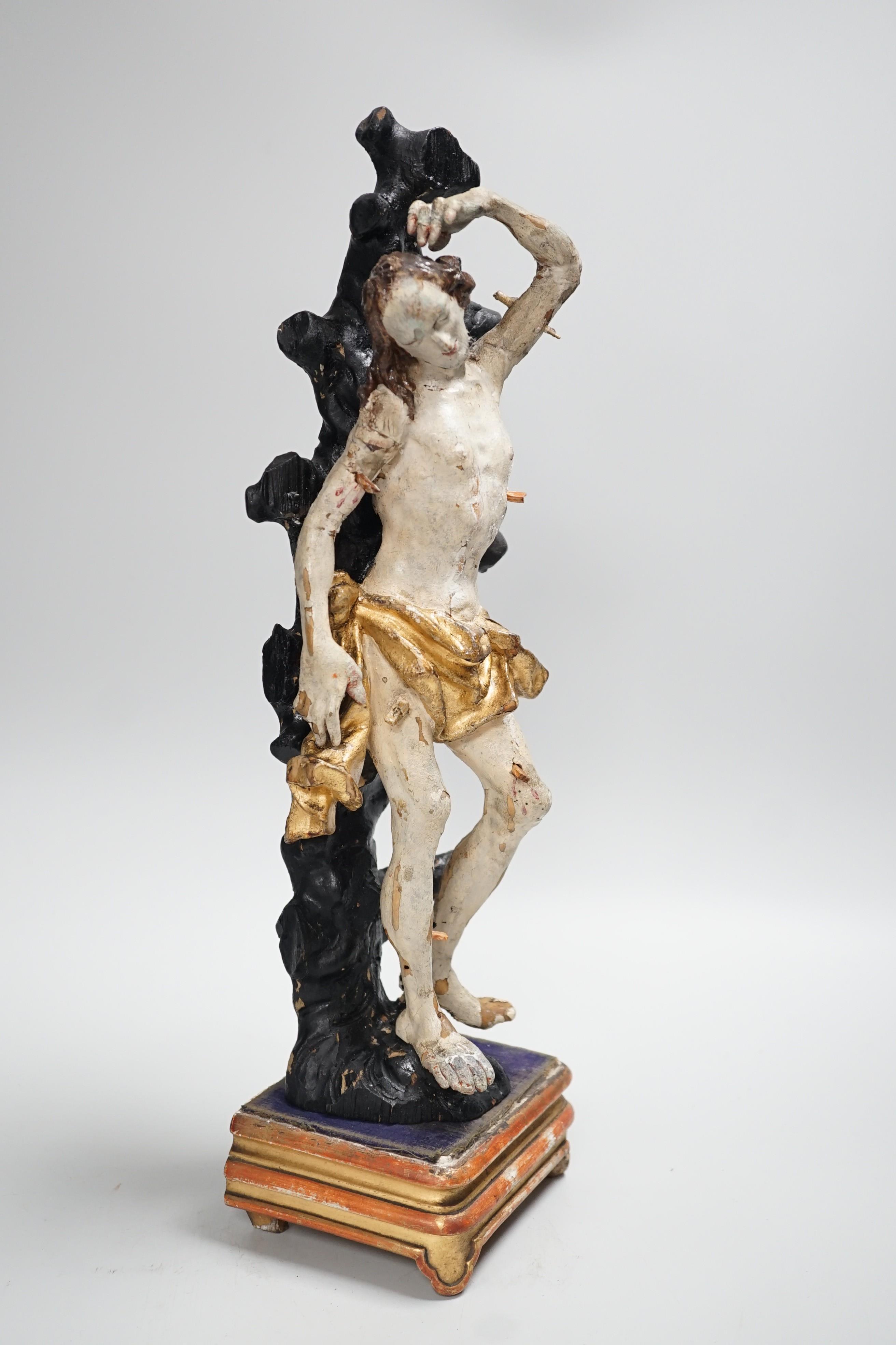 A 19th century Continental carved wooden polychrome figure of St. Sebastian on stand, total height 40cm